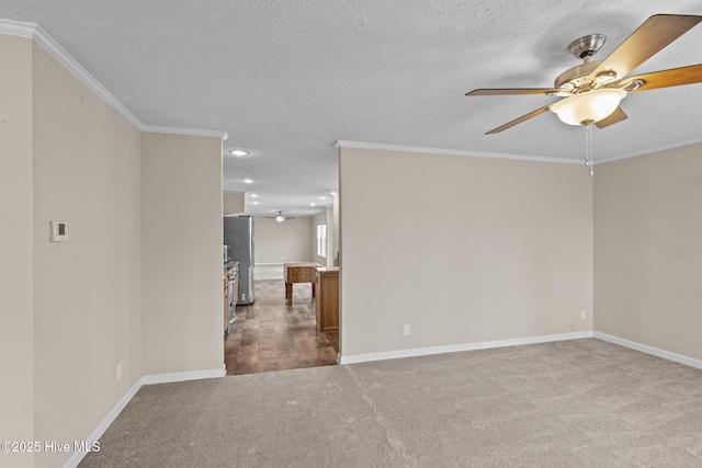 unfurnished room featuring ceiling fan, light colored carpet, ornamental molding, and a textured ceiling