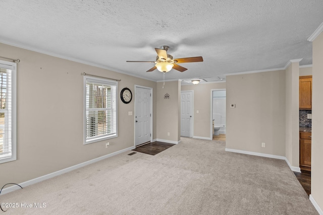 carpeted foyer entrance featuring ceiling fan, a textured ceiling, and ornamental molding