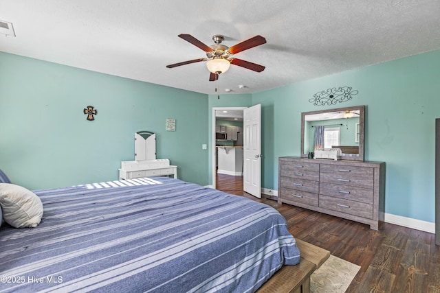 bedroom featuring ceiling fan, dark hardwood / wood-style flooring, and a textured ceiling