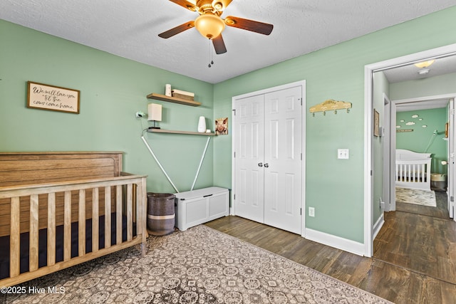 bedroom with ceiling fan, a closet, dark wood-type flooring, and a textured ceiling