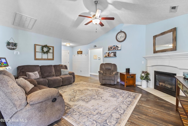 living room featuring a textured ceiling, ceiling fan, dark wood-type flooring, and lofted ceiling