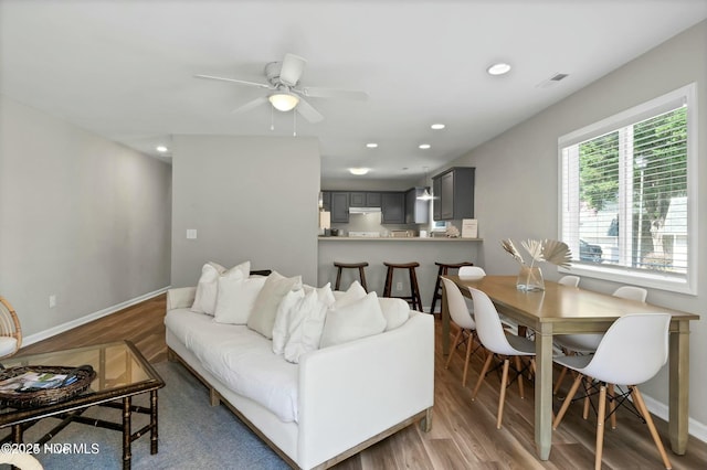 living room featuring wood-type flooring and ceiling fan