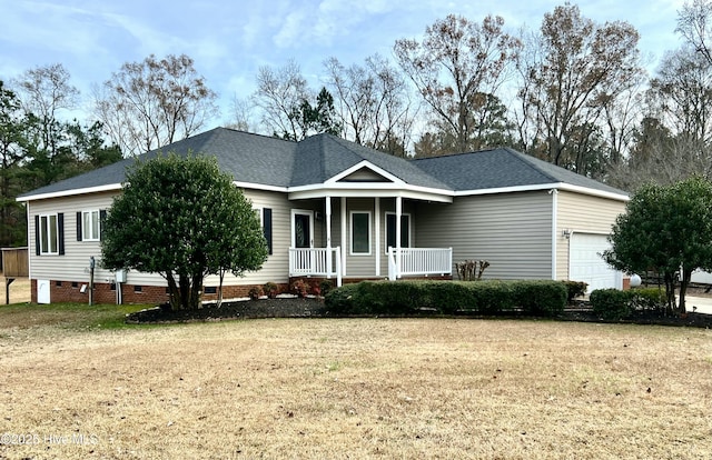 view of front of property featuring a front yard, covered porch, and a garage