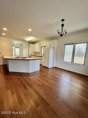 kitchen featuring dark wood-type flooring, white cabinets, white refrigerator with ice dispenser, and a chandelier