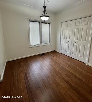 unfurnished bedroom featuring dark hardwood / wood-style flooring and a closet