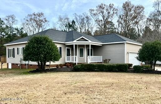 view of front of home featuring a garage, a front lawn, and covered porch