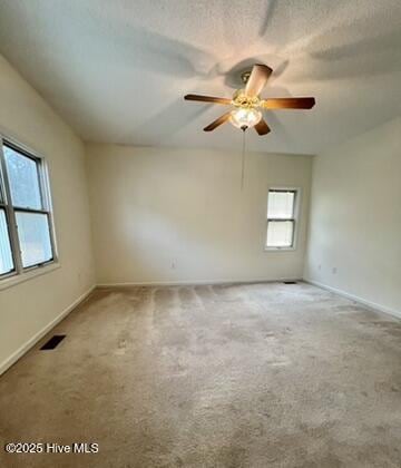 unfurnished room featuring ceiling fan, a textured ceiling, and carpet flooring