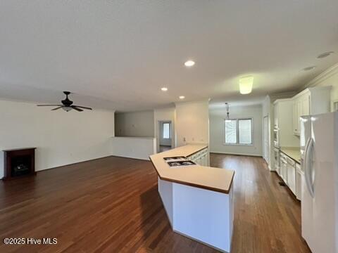 kitchen with white cabinetry, ceiling fan, white appliances, dark hardwood / wood-style flooring, and a kitchen island