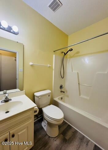 full bathroom featuring toilet, shower / bathtub combination, wood-type flooring, and vanity