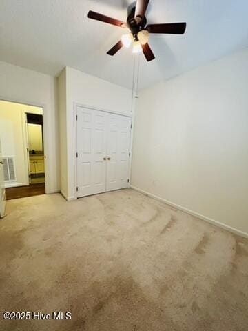 unfurnished bedroom featuring ceiling fan, a closet, and carpet