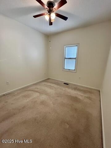 unfurnished room featuring ceiling fan and carpet