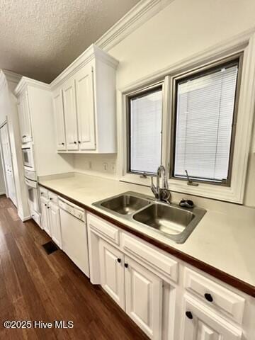 kitchen with sink, white appliances, white cabinetry, a textured ceiling, and dark hardwood / wood-style flooring