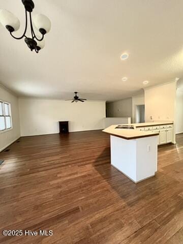 kitchen featuring ceiling fan with notable chandelier, a center island, decorative light fixtures, white cabinetry, and dark hardwood / wood-style flooring