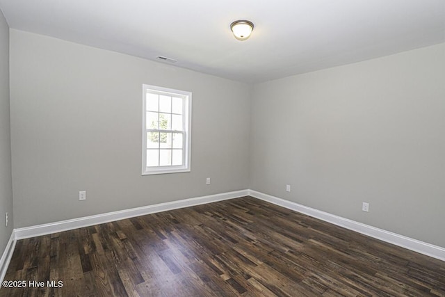 empty room with dark hardwood / wood-style flooring