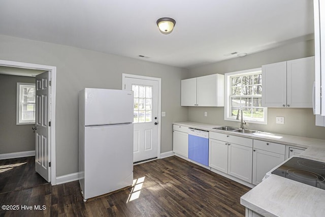 kitchen featuring white appliances, a wealth of natural light, sink, and white cabinets