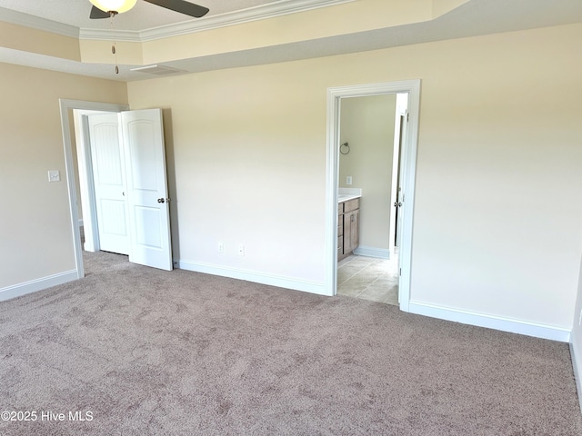 unfurnished bedroom featuring light carpet, a tray ceiling, ceiling fan, and crown molding