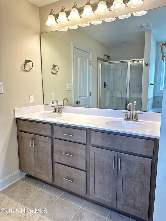 bathroom with tile patterned flooring, vanity, and walk in shower