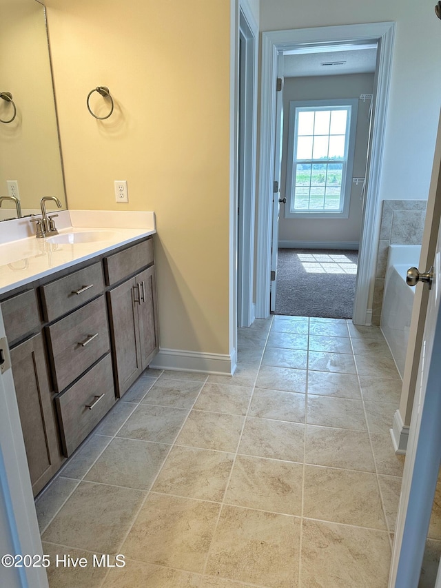 bathroom featuring a washtub, vanity, and tile patterned floors