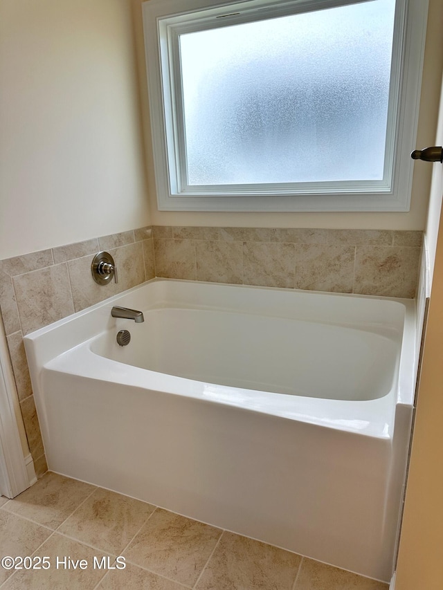 bathroom with a bathing tub, plenty of natural light, and tile patterned flooring