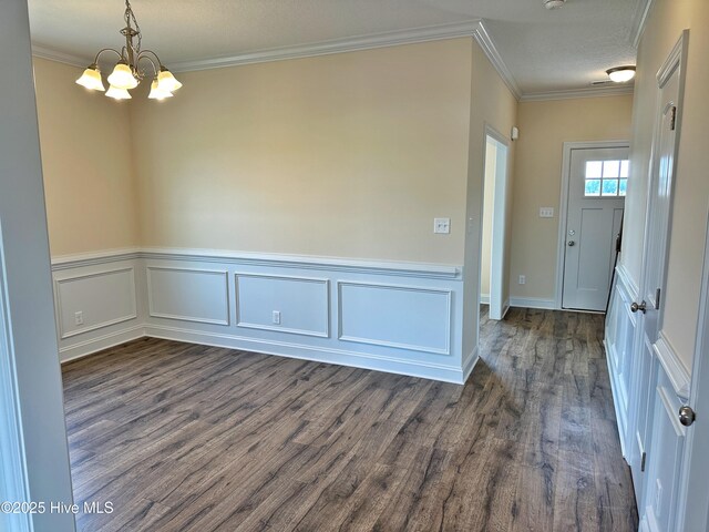 foyer with crown molding, dark wood-type flooring, a chandelier, and a textured ceiling