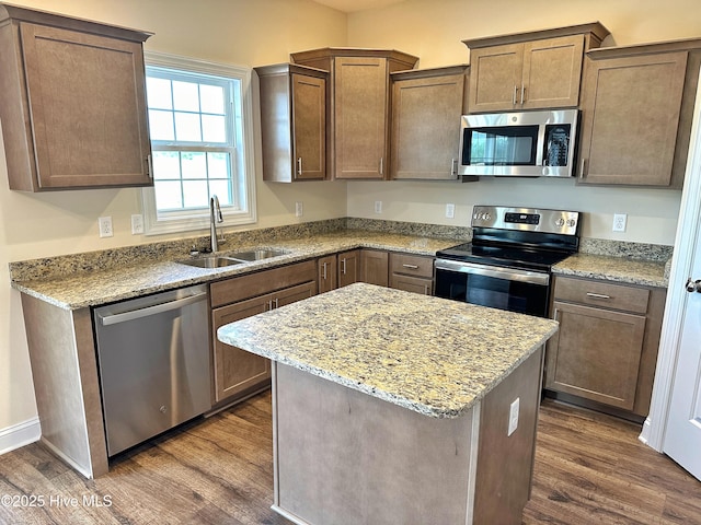 kitchen featuring light stone counters, sink, dark hardwood / wood-style floors, and appliances with stainless steel finishes