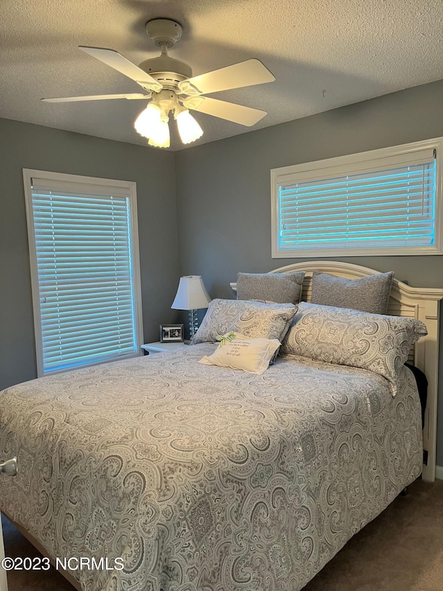 bedroom featuring ceiling fan and a textured ceiling