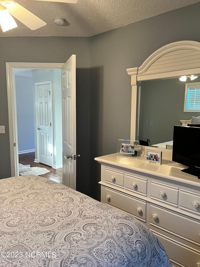 bedroom with ceiling fan and a textured ceiling