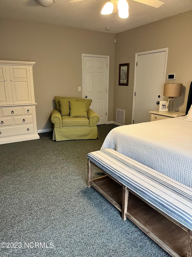 carpeted bedroom featuring ceiling fan and a textured ceiling