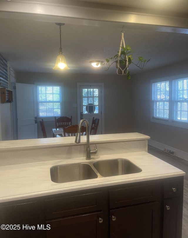 kitchen with dark brown cabinets, sink, and hanging light fixtures