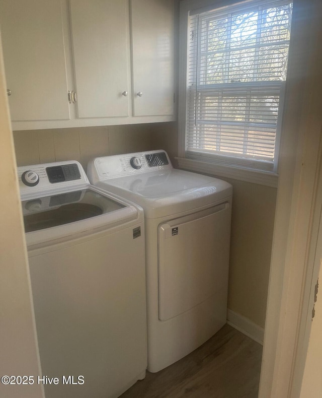 clothes washing area with hardwood / wood-style flooring, cabinets, and washing machine and clothes dryer