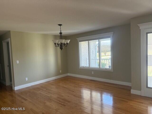 unfurnished dining area featuring light hardwood / wood-style flooring and a chandelier