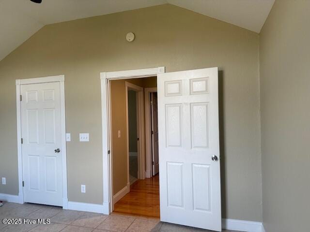 interior space with light tile patterned floors and vaulted ceiling