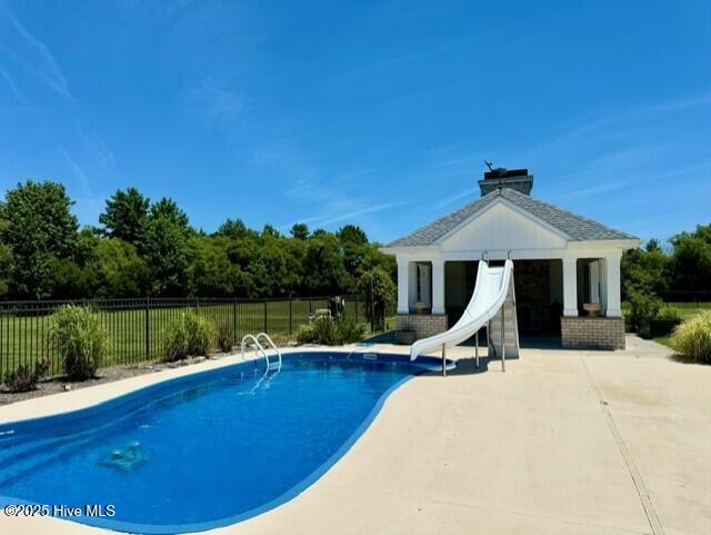 view of pool with a patio and a water slide