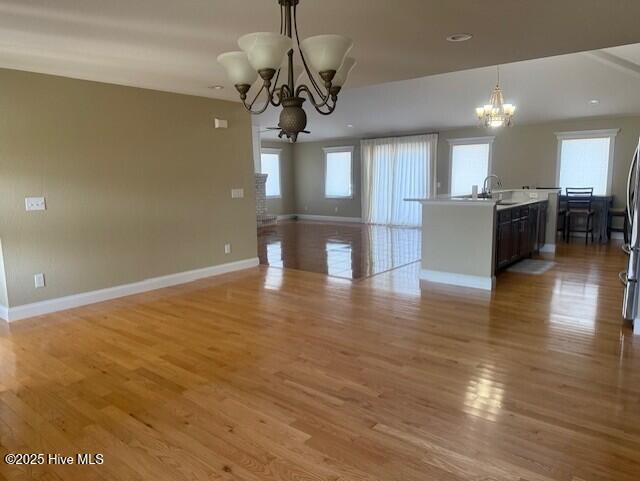 interior space featuring sink, light hardwood / wood-style flooring, and an inviting chandelier