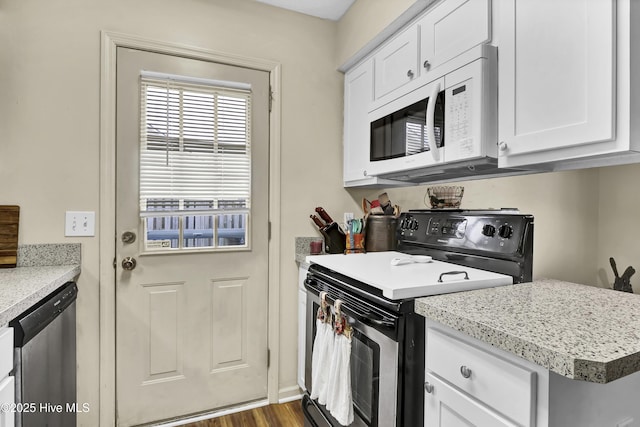 kitchen with dishwasher, hardwood / wood-style floors, white cabinetry, and electric stove