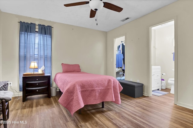 bedroom with ensuite bathroom, ceiling fan, and hardwood / wood-style flooring