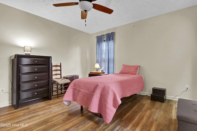 bedroom featuring hardwood / wood-style flooring, ceiling fan, and a textured ceiling