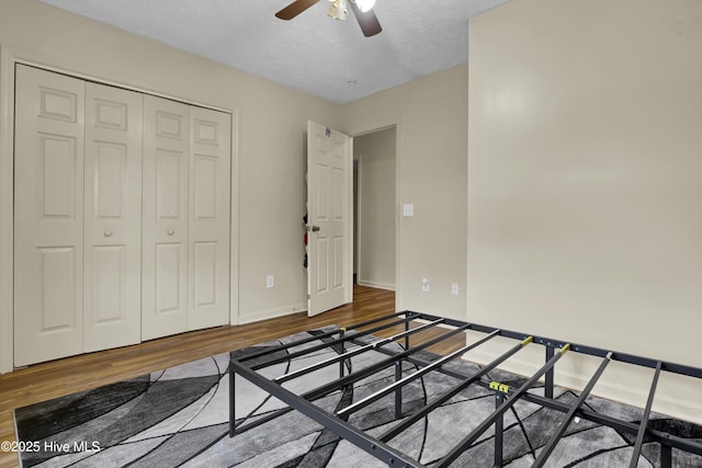 bedroom featuring ceiling fan, a closet, hardwood / wood-style floors, and a textured ceiling