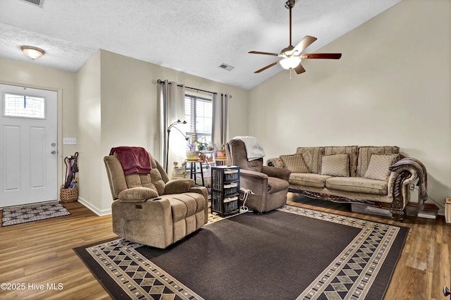 living room with ceiling fan, a textured ceiling, and hardwood / wood-style flooring