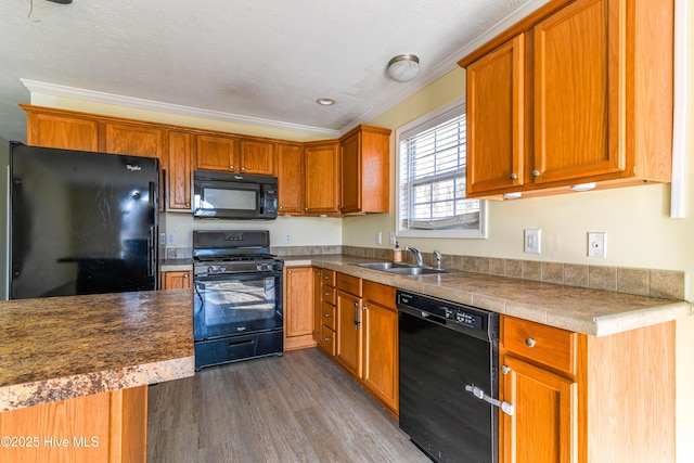 kitchen featuring dark hardwood / wood-style flooring, sink, ornamental molding, and black appliances