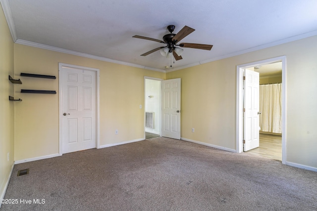 unfurnished bedroom featuring light colored carpet, ceiling fan, and crown molding