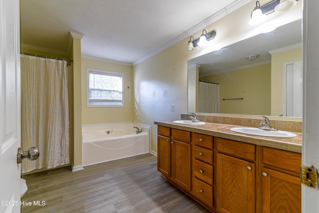 bathroom featuring a bathtub, a textured ceiling, vanity, crown molding, and wood-type flooring