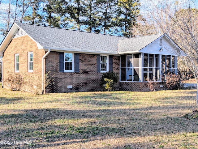 view of front of house with a front yard and a sunroom