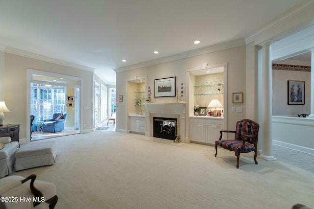 carpeted living room with ornamental molding and decorative columns