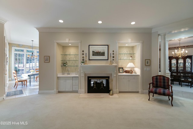 carpeted living room featuring sink, ornamental molding, and an inviting chandelier