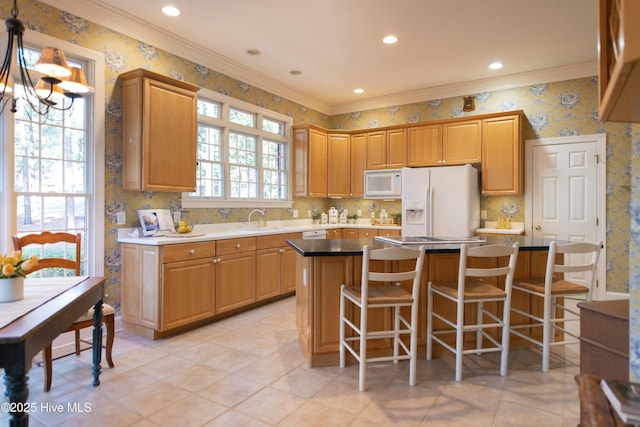 kitchen with a center island, white appliances, crown molding, sink, and a chandelier