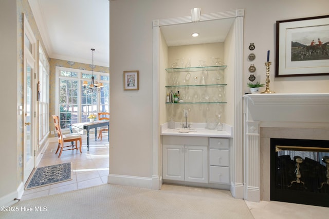 bathroom with tile patterned flooring, vanity, crown molding, and a chandelier