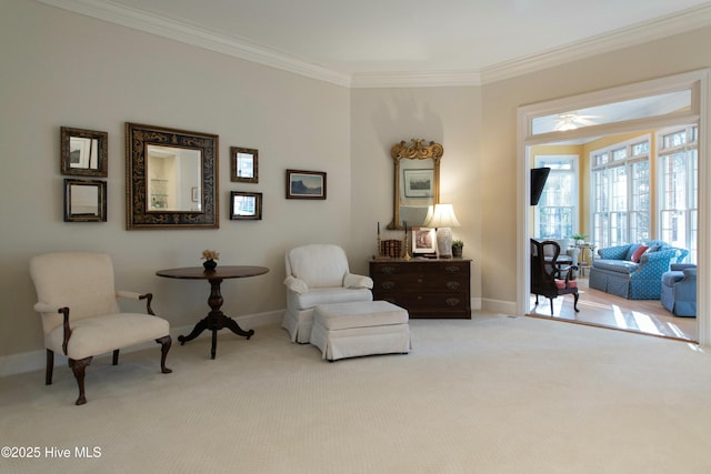 living area with ceiling fan, crown molding, and light carpet