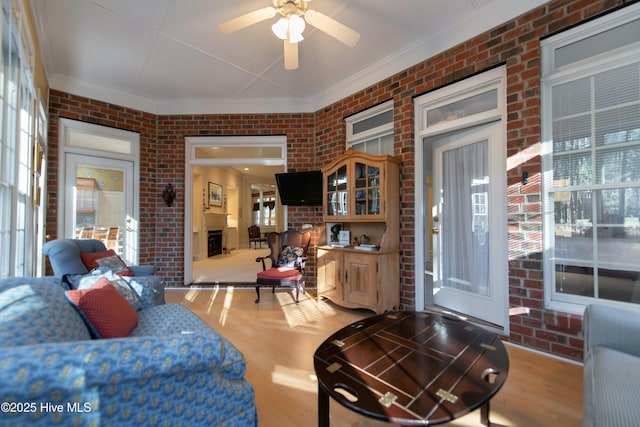 living room with ceiling fan and brick wall