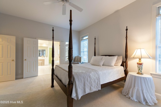 carpeted bedroom with ensuite bath and ceiling fan